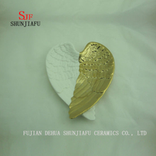 Prato de asas de anjo, a cor é branca e dourada, prato de doces em cerâmica