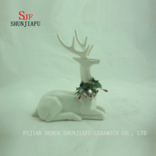 Os cervos cerâmicos sentam-se na decoração do Desktop da forma do assoalho, presente de época natalícia / a